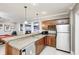 Modern basement kitchenette features wood cabinets with stainless fridge and bar access to basement living area at 7653 Carriage House Way, Zionsville, IN 46077