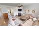 Bright living room featuring hardwood floors, a fireplace, and a ceiling fan at 7824 Gray Eagle Dr, Zionsville, IN 46077