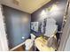 Cozy powder room with a pedestal sink, round mirror, and navy blue walls at 7824 Gray Eagle Dr, Zionsville, IN 46077