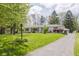 A charming bright white house with beautiful lawn and landscaping, complimented by driveway and US flag at 7950 Westfield Blvd, Indianapolis, IN 46240