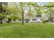 Charming, bright white home with well-maintained lawn, beautiful landscaping, and mature trees at 7950 Westfield Blvd, Indianapolis, IN 46240