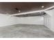 Large and empty garage featuring concrete flooring, textured ceiling, and an automatic garage door at 7950 Westfield Blvd, Indianapolis, IN 46240