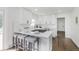 Modern white kitchen features stainless steel appliances, breakfast bar, and dark hardwood floors at 7950 Westfield Blvd, Indianapolis, IN 46240
