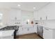 A bright, open kitchen featuring stainless steel appliances, white cabinetry, hardwood floors, and sink at 7950 Westfield Blvd, Indianapolis, IN 46240