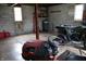 Spacious unfinished basement with a four-wheeler, a lawn tractor, and natural light from two windows at 8341 N Washington St, Sheridan, IN 46069