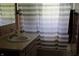Bathroom with a sink and vanity next to the shower with a striped shower curtain at 8341 N Washington St, Sheridan, IN 46069