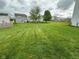 Spacious backyard featuring a large lawn and mature trees in a residential area at 8409 Bolero Way, Camby, IN 46113