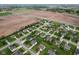 Bird's-eye view of a residential community with green lawns, mature trees, and farmland in the background at 901 Palomino Pl, Bargersville, IN 46106