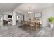 Bright dining room featuring hardwood floors, a modern light fixture and flows into an open living area at 901 Palomino Pl, Bargersville, IN 46106