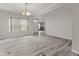 Bright living room with gray wood-look floors, white walls, and a large window with natural light at 901 Palomino Pl, Bargersville, IN 46106