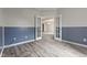 A view of a room with blue wainscoting and luxury vinyl plank flooring through double doors at 901 Palomino Pl, Bargersville, IN 46106