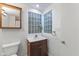 Cozy bathroom featuring a vanity with dark wood cabinetry, white countertop and a glass block window at 920 E 62Nd St # Apt M7, Indianapolis, IN 46220