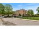 Angle shot of a brick building with mature trees, a black metal fence, and visible street parking at 920 E 62Nd St # Apt M7, Indianapolis, IN 46220