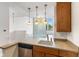 Kitchen with wood cabinets, gray countertops, stainless steel appliances, open to living area with a glass brick wall at 920 E 62Nd St # Apt M7, Indianapolis, IN 46220