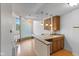 Open-concept kitchen with wood cabinets, gray countertops, glass brick wall feature, and hardwood floors at 920 E 62Nd St # Apt M7, Indianapolis, IN 46220
