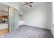Bright living room featuring neutral walls, a glass block wall, and a ceiling fan, seamlessly connected to the kitchen at 920 E 62Nd St # Apt M7, Indianapolis, IN 46220