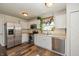 Bright kitchen with stainless steel appliances, white cabinetry, and a subway tile backsplash, creating a clean and modern cooking space at 9307 W Dockside Cir, Pendleton, IN 46064