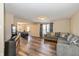 Spacious living room with a large gray sectional sofa, wood-style flooring, and a view into the adjacent dining area at 9307 W Dockside Cir, Pendleton, IN 46064