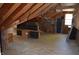 Unfinished attic featuring exposed beams and a window, with storage areas and a wooden floor at 931 Beech Dr, Greenwood, IN 46142