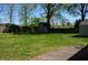 Spacious backyard with lush grass and mature trees, complete with a wooden fence and shed, ideal for outdoor enjoyment at 931 Beech Dr, Greenwood, IN 46142