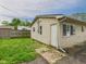 Exterior view of the backyard, featuring a grassy area and access to the house through a backdoor at 979 Monroe St, Indianapolis, IN 46229