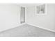 A light-filled room with plush carpeting, painted walls, a window, and a doorway creating a bright and inviting space at 979 Monroe St, Indianapolis, IN 46229