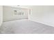 Bright living room features neutral paint, plush carpeting, and a large window at 979 Monroe St, Indianapolis, IN 46229