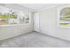 A bright sunroom features neutral walls, plush carpeting, and multiple windows offering views of the outdoors at 979 Monroe St, Indianapolis, IN 46229