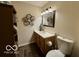 Bathroom with wood cabinets, white countertop, and mirror with vanity lighting at 1018 Redwood Dr, Lebanon, IN 46052