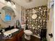 Updated powder room featuring floral wallpaper, granite countertop and round mirror at 1018 Redwood Dr, Lebanon, IN 46052