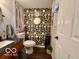 Updated powder room featuring floral wallpaper and a granite countertop at 1018 Redwood Dr, Lebanon, IN 46052