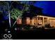 Charming home with warm interior lighting, a cozy front porch, and inviting landscaping at night at 1018 Redwood Dr, Lebanon, IN 46052