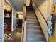 Inviting foyer with a staircase, hardwood floors, and views into the kitchen and dining areas at 1018 Redwood Dr, Lebanon, IN 46052