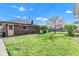 Backyard with lush green grass, mature trees, and a charming brick home exterior creating a serene outdoor space at 1029 E Yoke St, Indianapolis, IN 46203