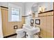 Bathroom featuring a stylish pedestal sink, ornate lighting, and colorful glass window at 1029 E Yoke St, Indianapolis, IN 46203