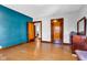 Bedroom showcasing blue accent wall, hardwood floors, and paneled wood doors at 1029 E Yoke St, Indianapolis, IN 46203