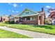 Brick home with a covered porch and well-manicured lawn under a clear blue sky at 1029 E Yoke St, Indianapolis, IN 46203