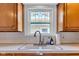 This kitchen features tile backsplash, a stainless steel faucet, and a window with stained glass at 1029 E Yoke St, Indianapolis, IN 46203