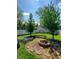 Backyard with thriving garden beds, firepit and white fence surrounded by mature trees at 1050 Jefferson Ave, Indianapolis, IN 46201