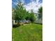 Backyard featuring mature trees, a white picket fence, and verdant green space at 1050 Jefferson Ave, Indianapolis, IN 46201