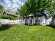 Green backyard showcasing a lush lawn, white picket fence, and cozy patio area at 1050 Jefferson Ave, Indianapolis, IN 46201