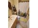 Bathroom with a single sink vanity, decorative cactus shower curtain, and yellow bath mat at 1050 Jefferson Ave, Indianapolis, IN 46201