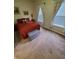 Bedroom with a red bedspread, matching pillows, bedside tables with lamps, and patterned curtains at 1050 Jefferson Ave, Indianapolis, IN 46201