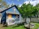 Charming home exterior boasting vibrant blue siding, bright yellow door, and well-kept lawn and garden at 1050 Jefferson Ave, Indianapolis, IN 46201