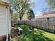 Fenced backyard with a wooden bench and a rustic fire pit at 106 Walnut St, Southport, IN 46227