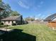 Expansive backyard with a well-maintained lawn and a wooden fence under a clear blue sky at 106 Walnut St, Southport, IN 46227