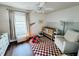 Bedroom with a crib, chair, and playful decor, showcasing a bright and inviting space at 106 Walnut St, Southport, IN 46227