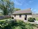 Garage exterior with a patio set nearby, green grass, and mature trees at 106 Walnut St, Southport, IN 46227