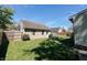 Backyard and garage area features a garage and a seating area, all set against a sunny backdrop at 106 Walnut St, Southport, IN 46227