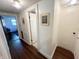 Well-lit hallway with white walls, wood flooring, and doorways to various rooms in the home at 106 Walnut St, Southport, IN 46227
